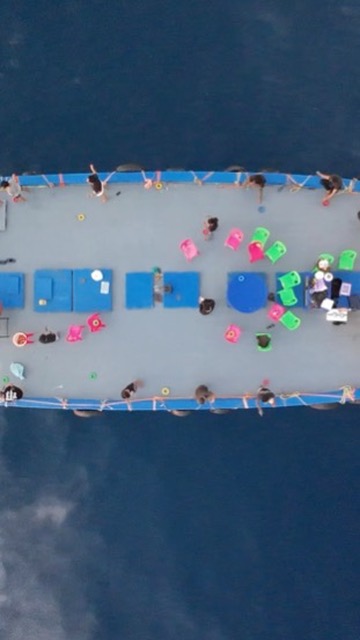 Top-down aerial of a boat party event on the ocean